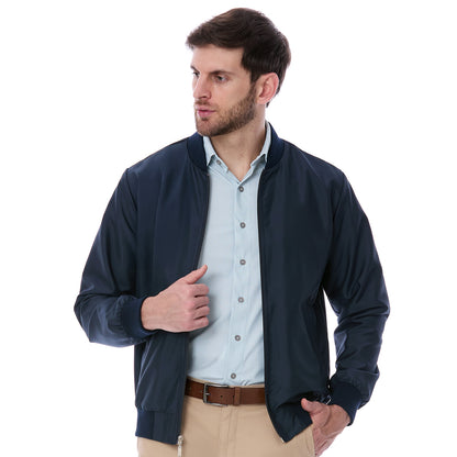 Modelo masculino vistiendo chamarra azul marino Vittorio Forti vista de frente, confeccionada en tela satinada con cierre metálico y puños elásticos, ideal para un look casual y elegante de caballero.