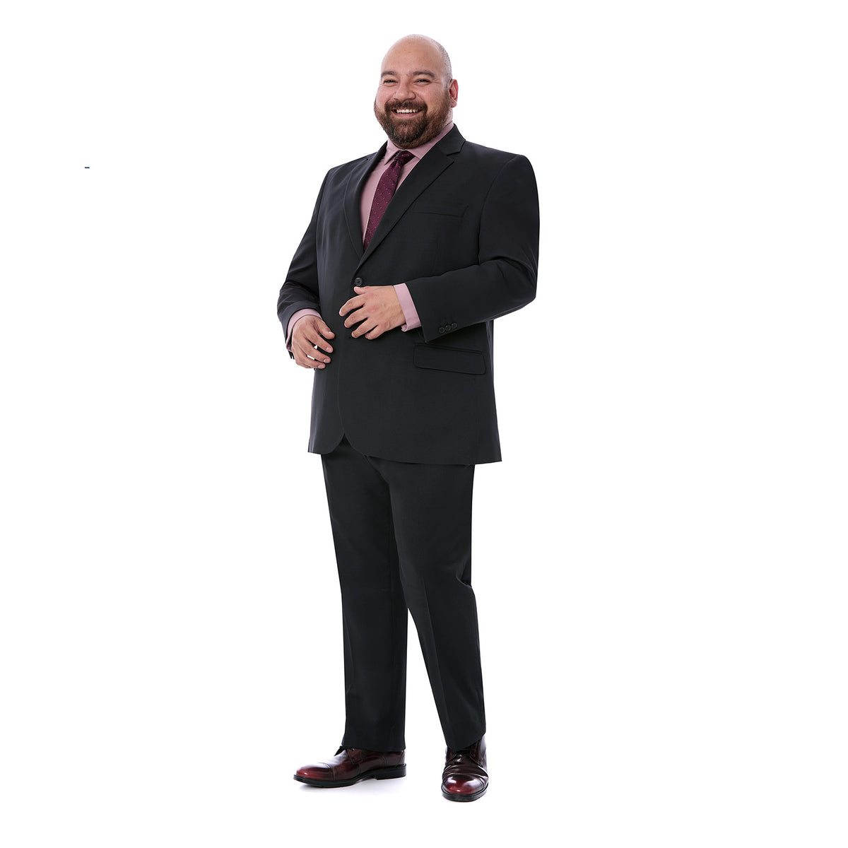 Plano medio de hombre feliz vistiendo un traje negro de talla grande con solapa de muesca. El hombre tiene la mano sobre el saco abrochado en un botón.