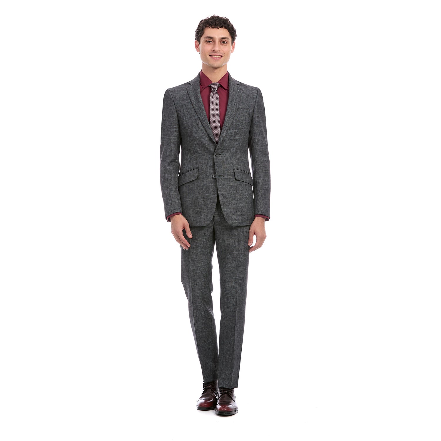 Hombre vistiendo traje formal color gris con diseño a rayas finas, corte slim fit. El conjunto incluye saco de dos botones con solapa clásica y pantalón recto a juego.Outfit elegante ideal para oficina o eventos formales