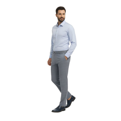 Hombre portando camisa formal color azul corte Extra Slim de la marca Vittorio Forti combinada con unos pantalones color gris perfevto para un atuendo de oficina o cualquier ocasión